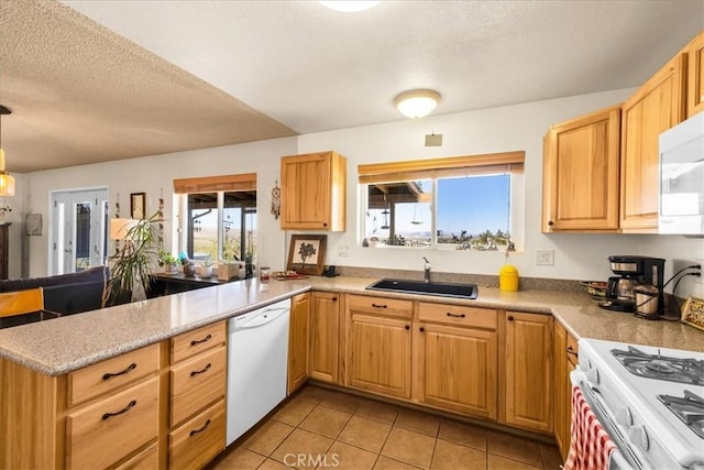 kitchen with a peninsula, light tile patterned flooring, white appliances, light countertops, and a sink