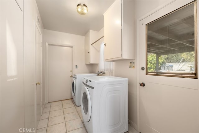 laundry room with cabinet space, light tile patterned floors, and washer and dryer