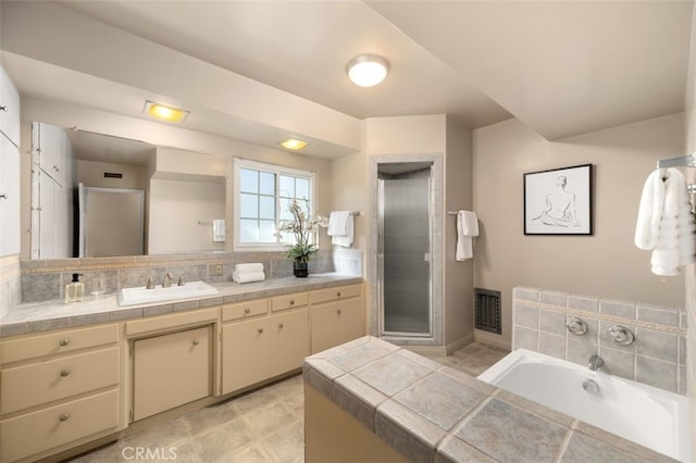 bathroom with visible vents, a bath, a stall shower, and vanity