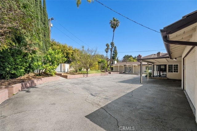 view of patio with an outdoor structure and a storage shed