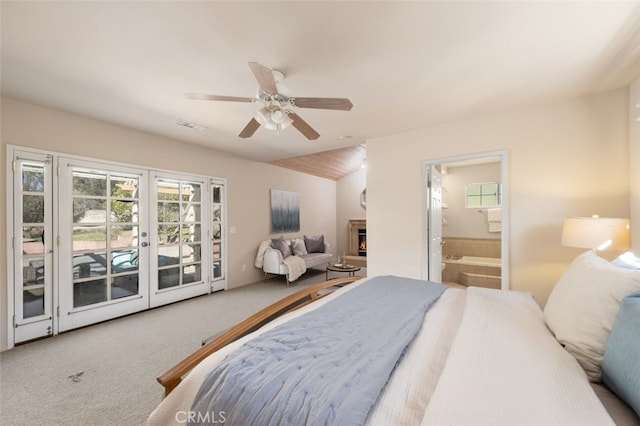 carpeted bedroom featuring french doors, access to exterior, visible vents, a warm lit fireplace, and connected bathroom