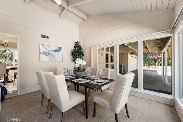 carpeted dining space with wooden walls, an inviting chandelier, beamed ceiling, visible vents, and wood ceiling