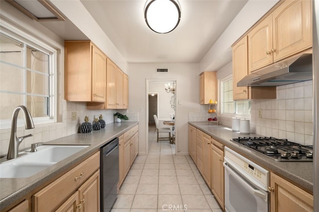 kitchen featuring light brown cabinetry, white oven, a sink, dishwashing machine, and under cabinet range hood