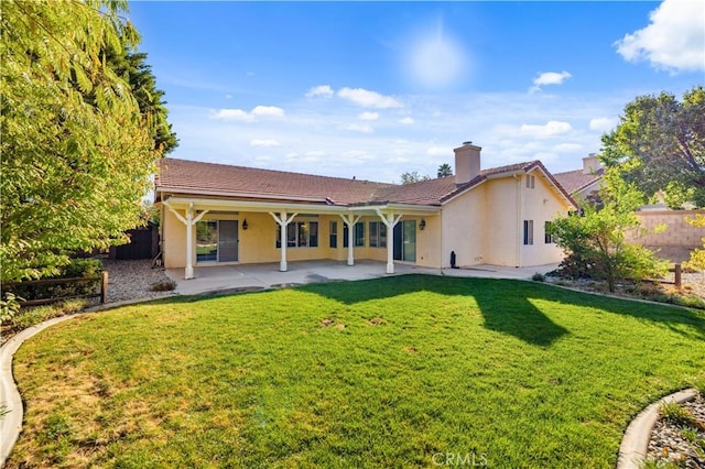 40949 Granite St, Palmdale, CA 93551 - rear view of house featuring fence, a patio, stucco siding, and a chimney