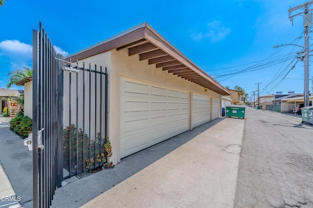 view of side of property with a detached garage and stucco siding
