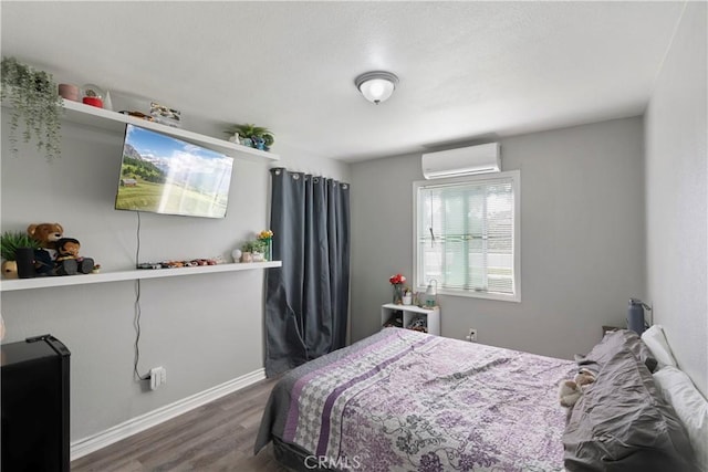 2113 Herrington Ave, San Bernardino, CA 92411 - bedroom featuring baseboards, a wall mounted air conditioner, and wood finished floors