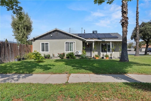 2113 Herrington Ave, San Bernardino, CA 92411 - bungalow-style house with fence, a front yard, stucco siding, ac unit, and solar panels