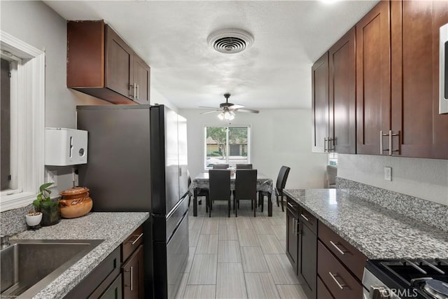 2113 Herrington Ave, San Bernardino, CA 92411 - kitchen featuring ceiling fan, appliances with stainless steel finishes, light stone countertops, a sink, and visible vents