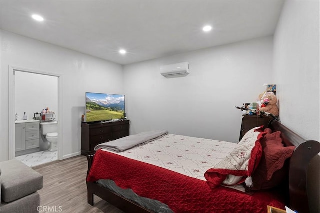 2113 Herrington Ave, San Bernardino, CA 92411 - bedroom with connected bathroom, recessed lighting, a wall mounted air conditioner, and wood finished floors