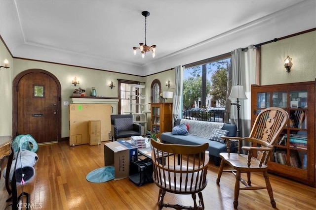 living area featuring wood-type flooring, arched walkways, and a chandelier