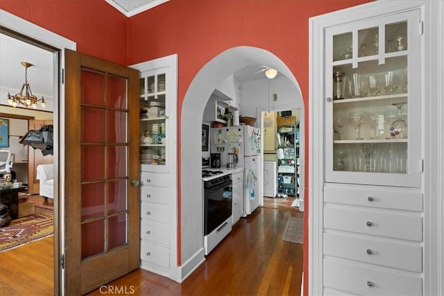 hallway with arched walkways and dark wood-type flooring