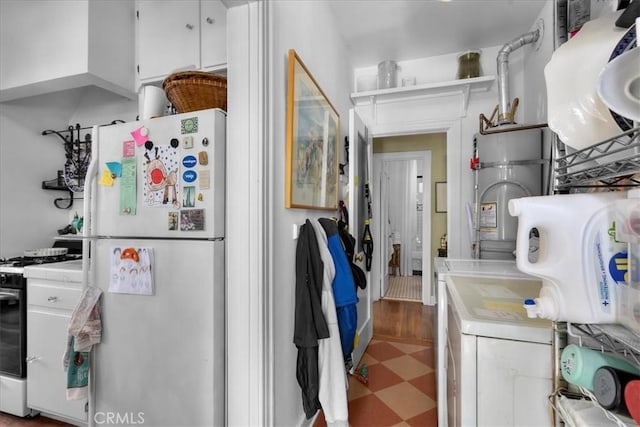 kitchen with freestanding refrigerator, open shelves, gas range, tile patterned floors, and white cabinets