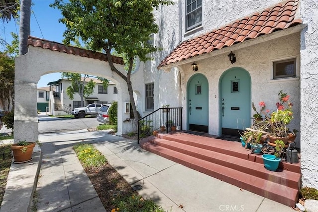 property entrance featuring stucco siding and a tiled roof