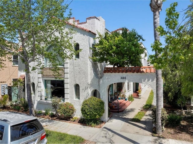 view of front of house featuring stucco siding and a tiled roof