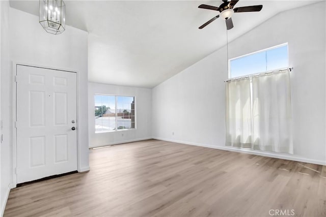 unfurnished living room with baseboards, ceiling fan, vaulted ceiling, and wood finished floors