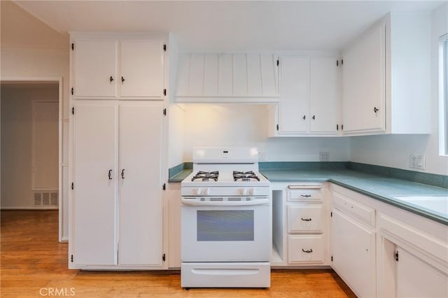 21122 Amberwick Ln, Huntington Beach, CA 92646 - kitchen featuring white cabinetry, white gas range, light wood-style floors, and wall chimney exhaust hood