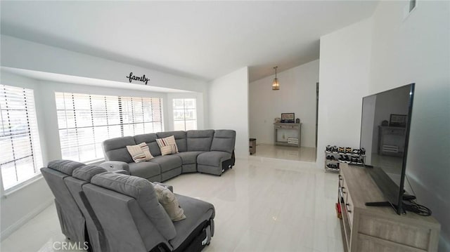 living room featuring baseboards, plenty of natural light, and lofted ceiling