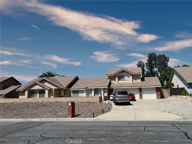 view of front of home featuring fence, driveway, and a tile roof