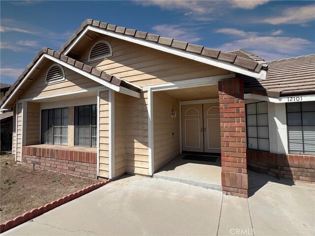 doorway to property with a tile roof