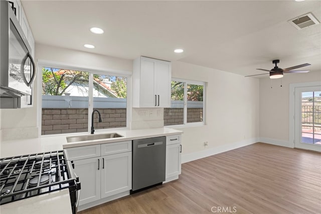 9239 Stone Canyon Rd, Corona, CA 92883 - kitchen featuring visible vents, a sink, light countertops, stainless steel appliances, and light wood-style flooring