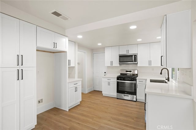 9239 Stone Canyon Rd, Corona, CA 92883 - kitchen featuring visible vents, recessed lighting, white cabinetry, a sink, and appliances with stainless steel finishes