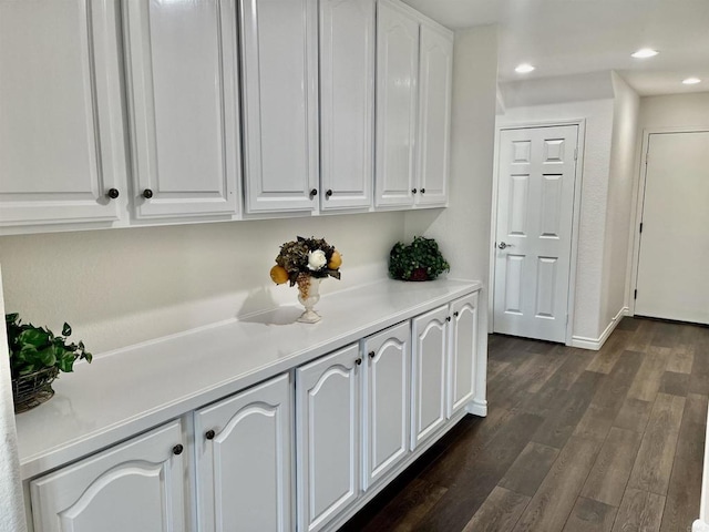 hall featuring recessed lighting, baseboards, and dark wood finished floors