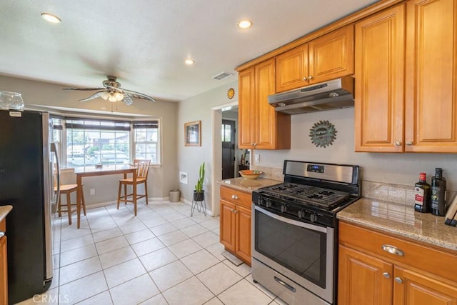kitchen featuring stainless steel appliances, visible vents, baseboards, ceiling fan, and under cabinet range hood