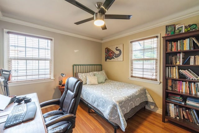 bedroom with ornamental molding, baseboards, a ceiling fan, and wood finished floors