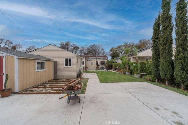 back of house with a lawn, an outbuilding, a patio, and a pergola