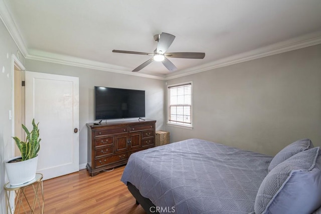bedroom featuring light wood-type flooring, baseboards, a ceiling fan, and ornamental molding
