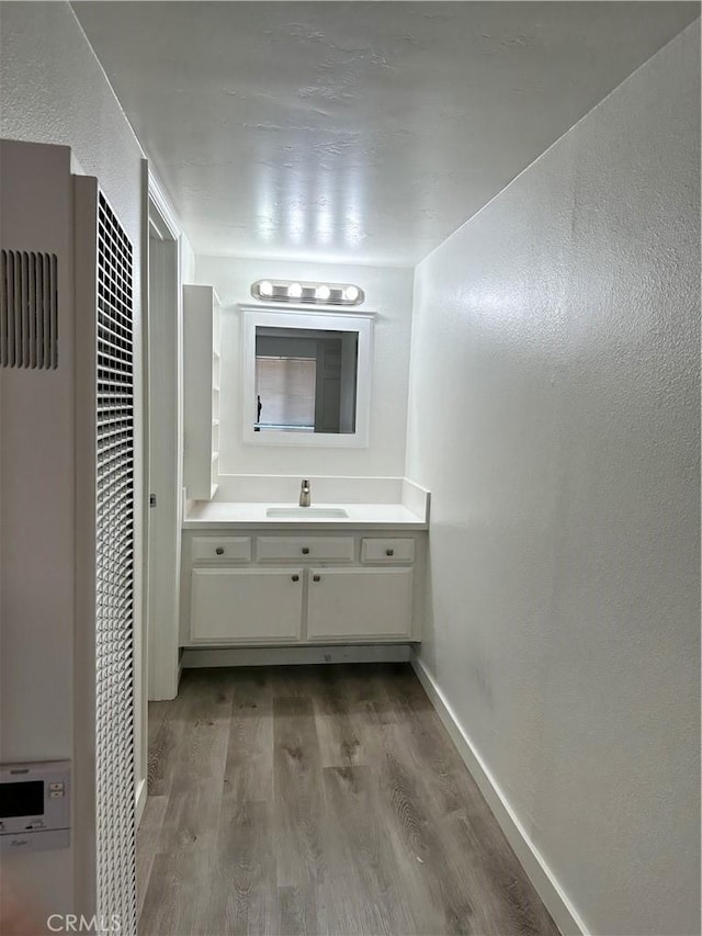 615 Calle Campana, San Clemente, CA 92673 - bathroom featuring baseboards, vanity, wood finished floors, and a heating unit