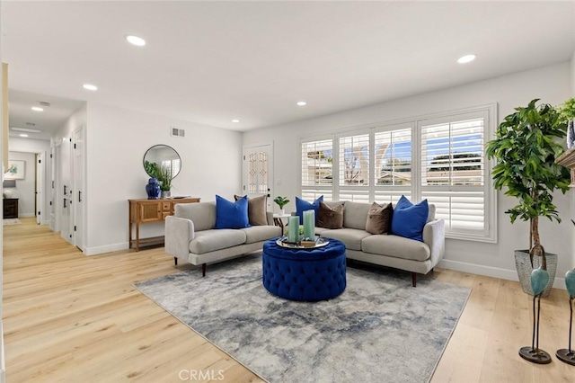 living room featuring recessed lighting, baseboards, light wood-type flooring, and visible vents