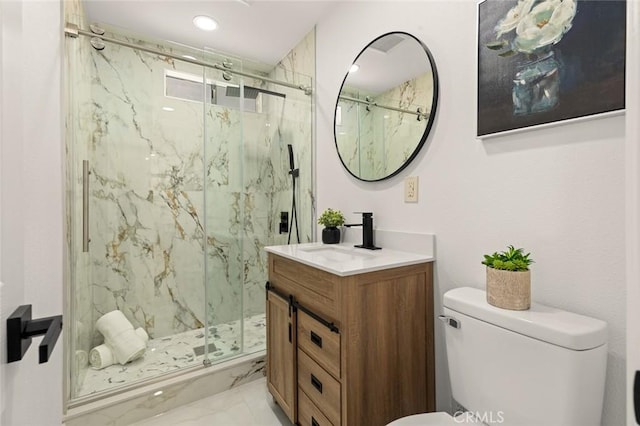 bathroom featuring vanity, a marble finish shower, and toilet