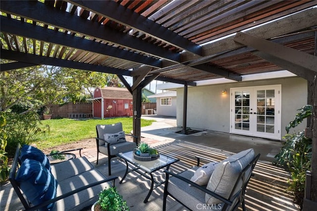 view of patio / terrace featuring french doors, a fenced backyard, a storage unit, a pergola, and outdoor lounge area