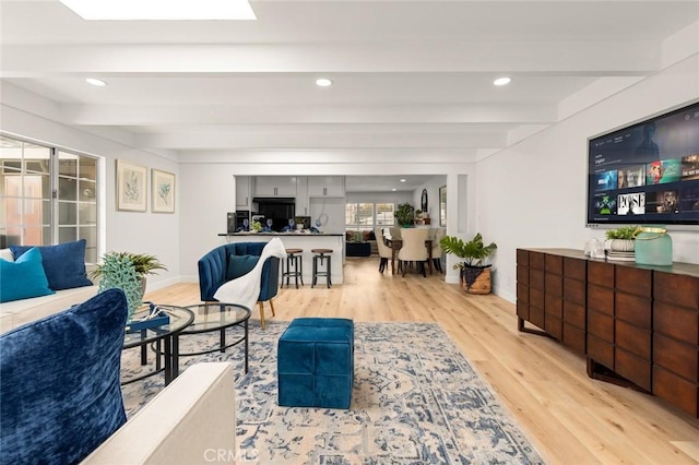 living room with recessed lighting, baseboards, beamed ceiling, and light wood finished floors