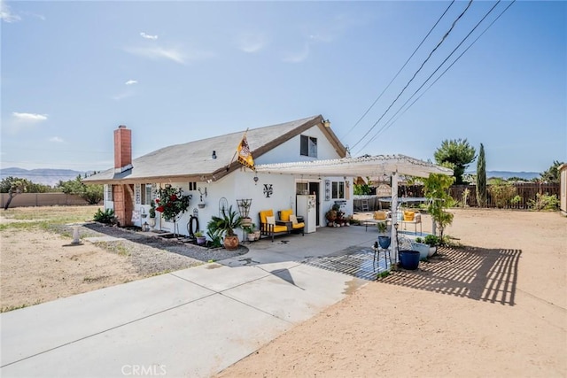 7120 Lyons Ave, Hesperia, CA 92345 - view of front of property featuring a patio, fence, a chimney, and stucco siding