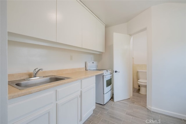 kitchen with wood finish floors, light countertops, white cabinets, white stove, and a sink