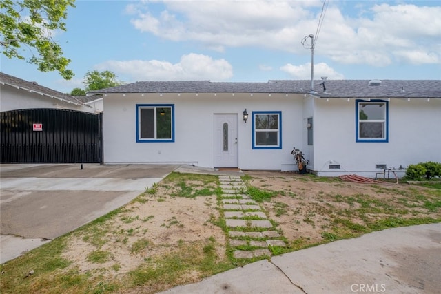 single story home with a gate and a shingled roof