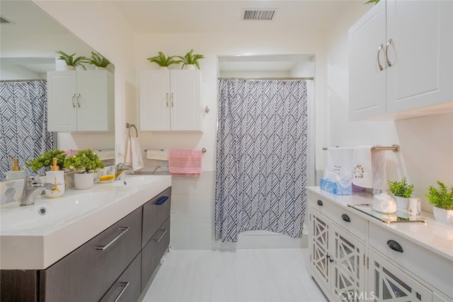 bathroom with visible vents, a sink, double vanity, and a shower with curtain