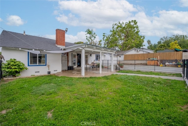 back of property with a lawn, a fenced backyard, a chimney, and a patio