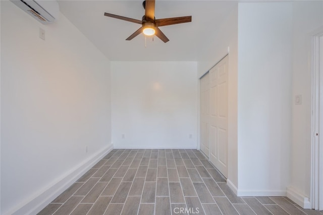 empty room with baseboards, a ceiling fan, wood finished floors, and an AC wall unit
