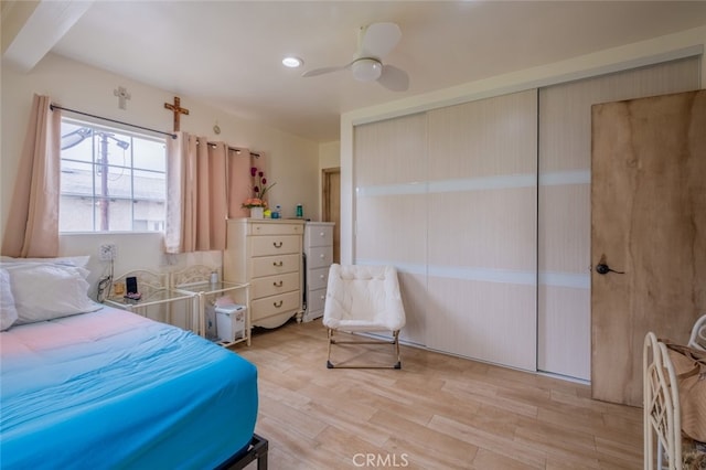 bedroom with ceiling fan, light wood-style flooring, and a closet