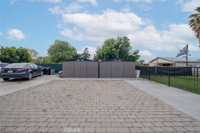 exterior space featuring decorative driveway, a gate, and fence