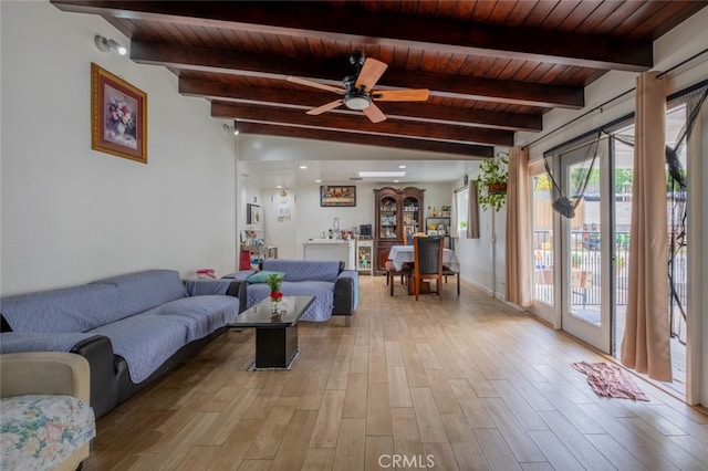 living area featuring wood ceiling, lofted ceiling with beams, a ceiling fan, and light wood-style flooring