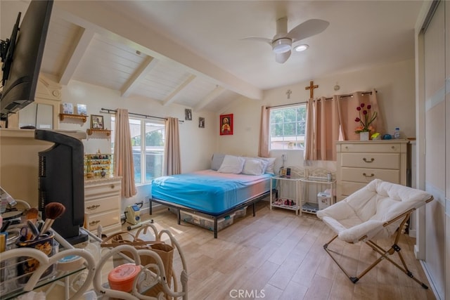 bedroom with a ceiling fan, vaulted ceiling with beams, and light wood-style floors