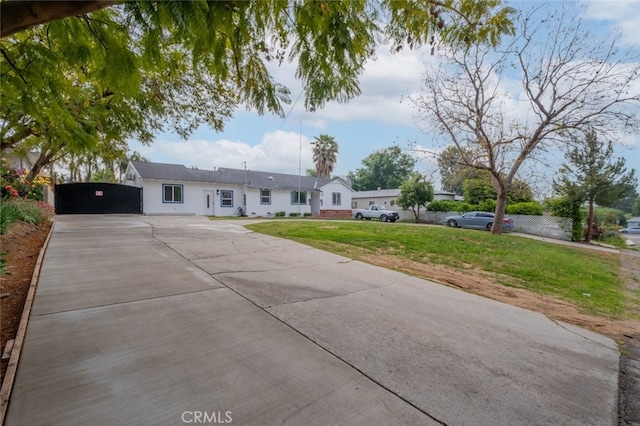 single story home with a front lawn, stucco siding, and driveway