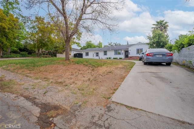 single story home with fence, driveway, and a front lawn