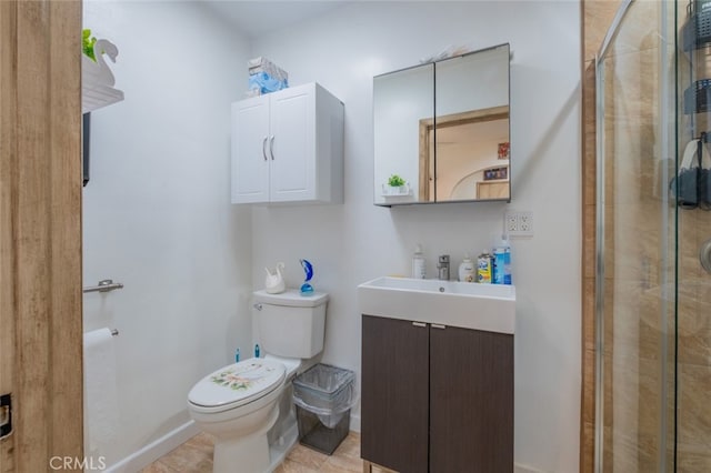 bathroom featuring vanity, baseboards, a stall shower, and toilet