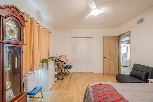 bedroom with visible vents, a ceiling fan, wood finished floors, and a closet