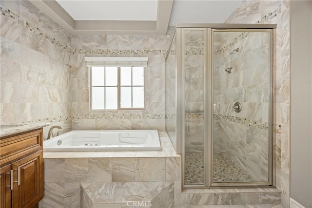 bathroom featuring a shower stall, a bath, and vanity